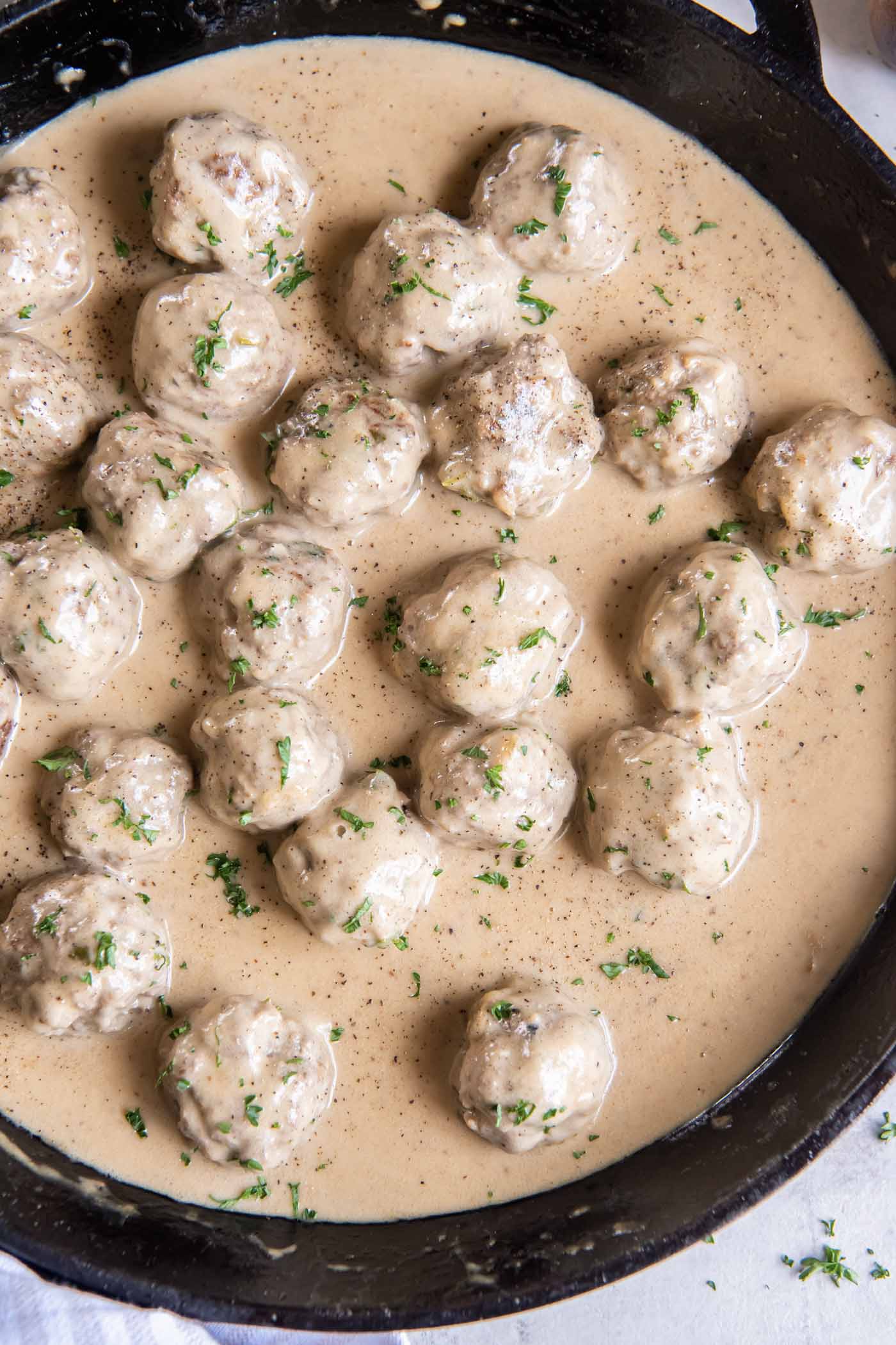 Swedish meatballs and gravy in a cast iron skillet.