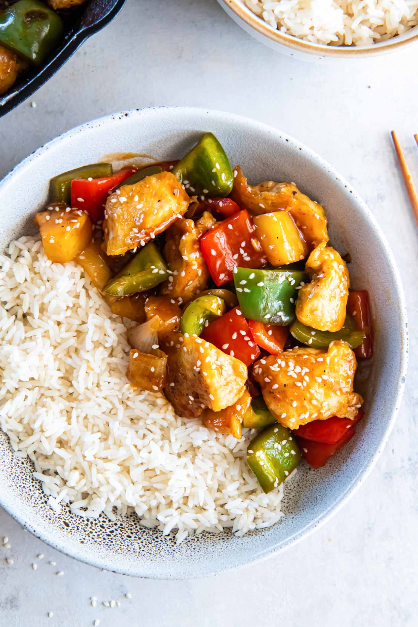 Sweet and sour chicken served in a bowl with white rice.