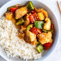 Sweet and sour chicken served in a bowl with white rice.