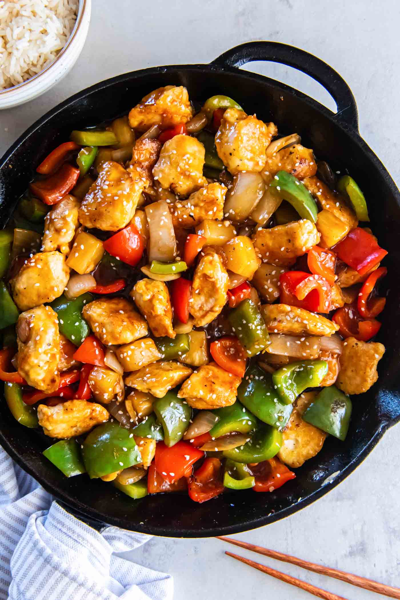 Sweet and sour chicken in a cast iron skillet.