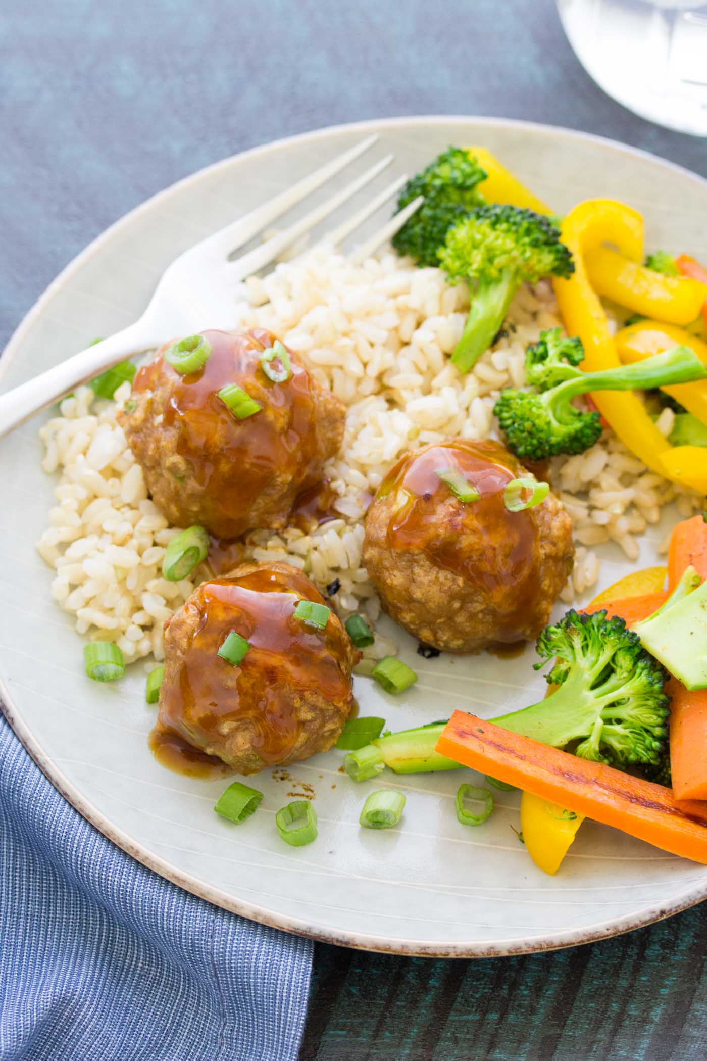 Three sweet and sour turkey meatballs served with brown rice and vegetables.