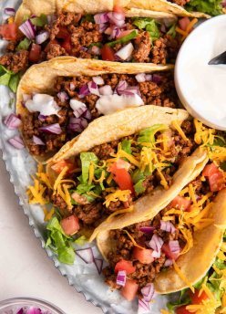 Ground beef taco meat served in soft corn tortillas with a variety of toppings.