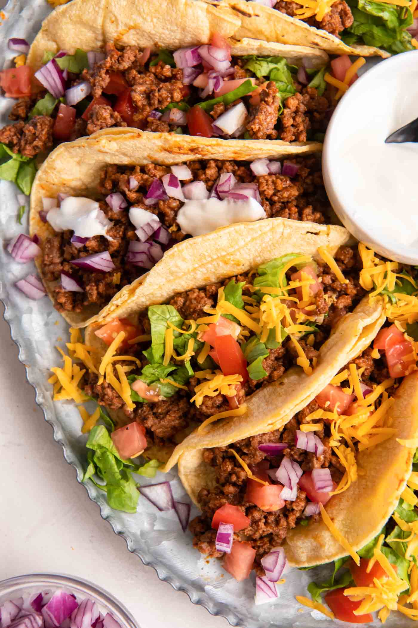 Ground beef taco meat served in soft corn tortillas with a variety of toppings.