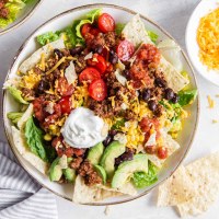 Taco salad with ground beef taco meat served in salad bowl.