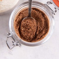 Homemade taco seasoning in a jar with a spoon.