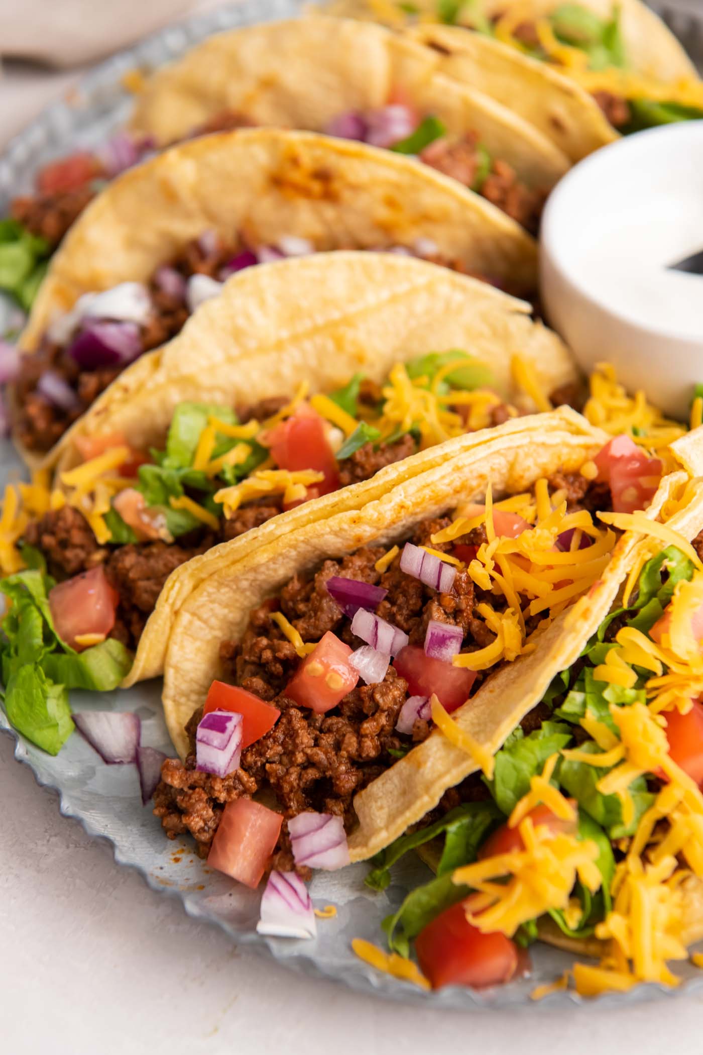 Ground beef tacos in corn tortillas with toppings.