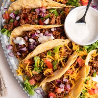 Ground beef tacos in corn tortillas with a variety of toppings.