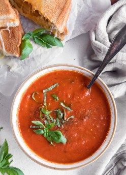 Tomato soup in a bowl garnished with fresh basil.