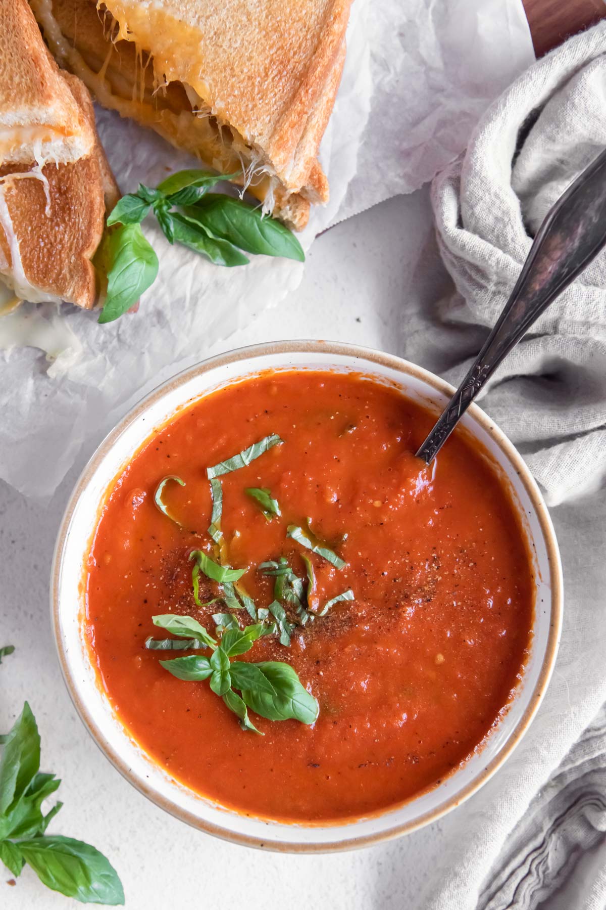 Tomato soup in a bowl garnished with fresh basil.
