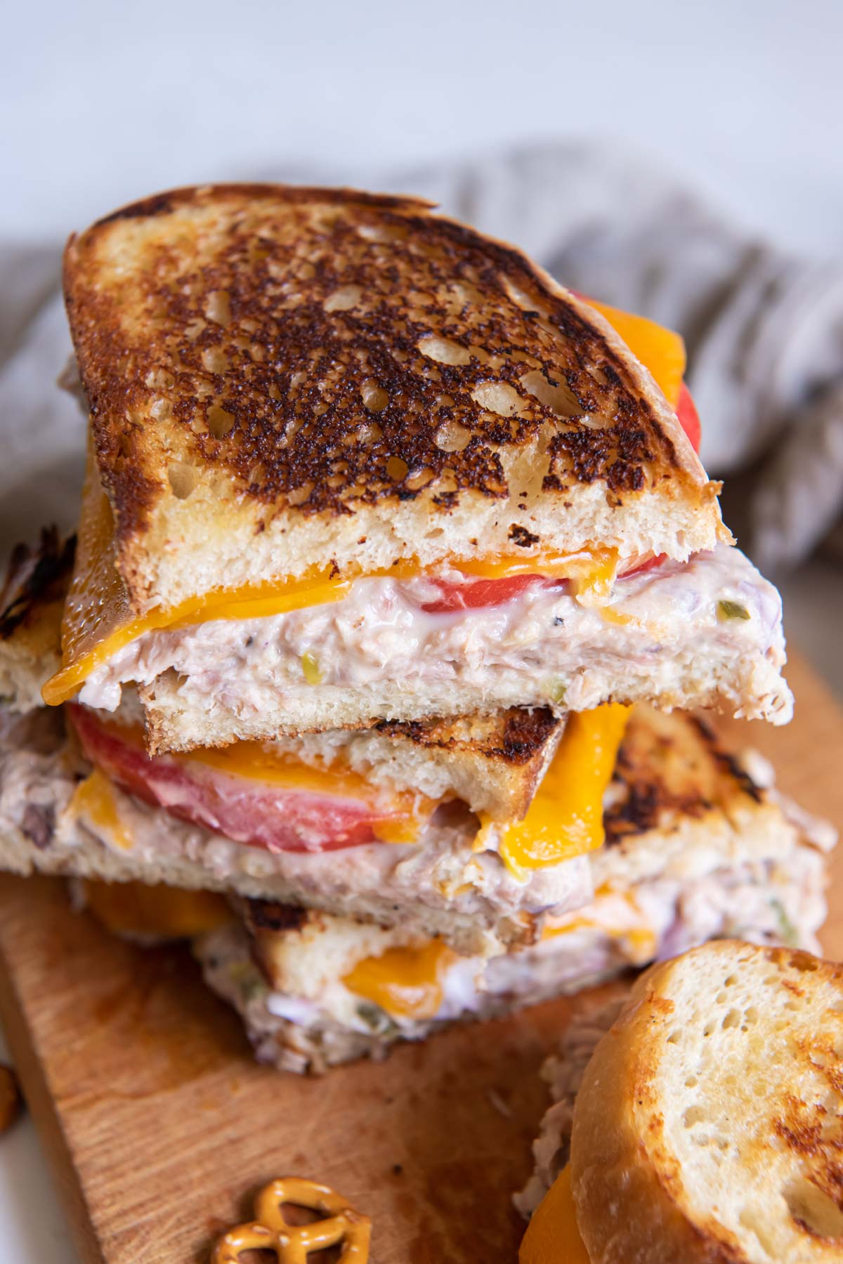 Stack of tuna melt sandwiches with tomato.
