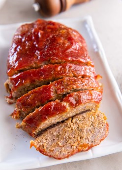 Partially sliced turkey meatloaf on a serving platter.