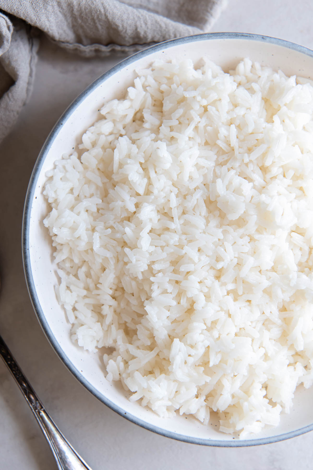Cooked white rice in a white serving bowl.